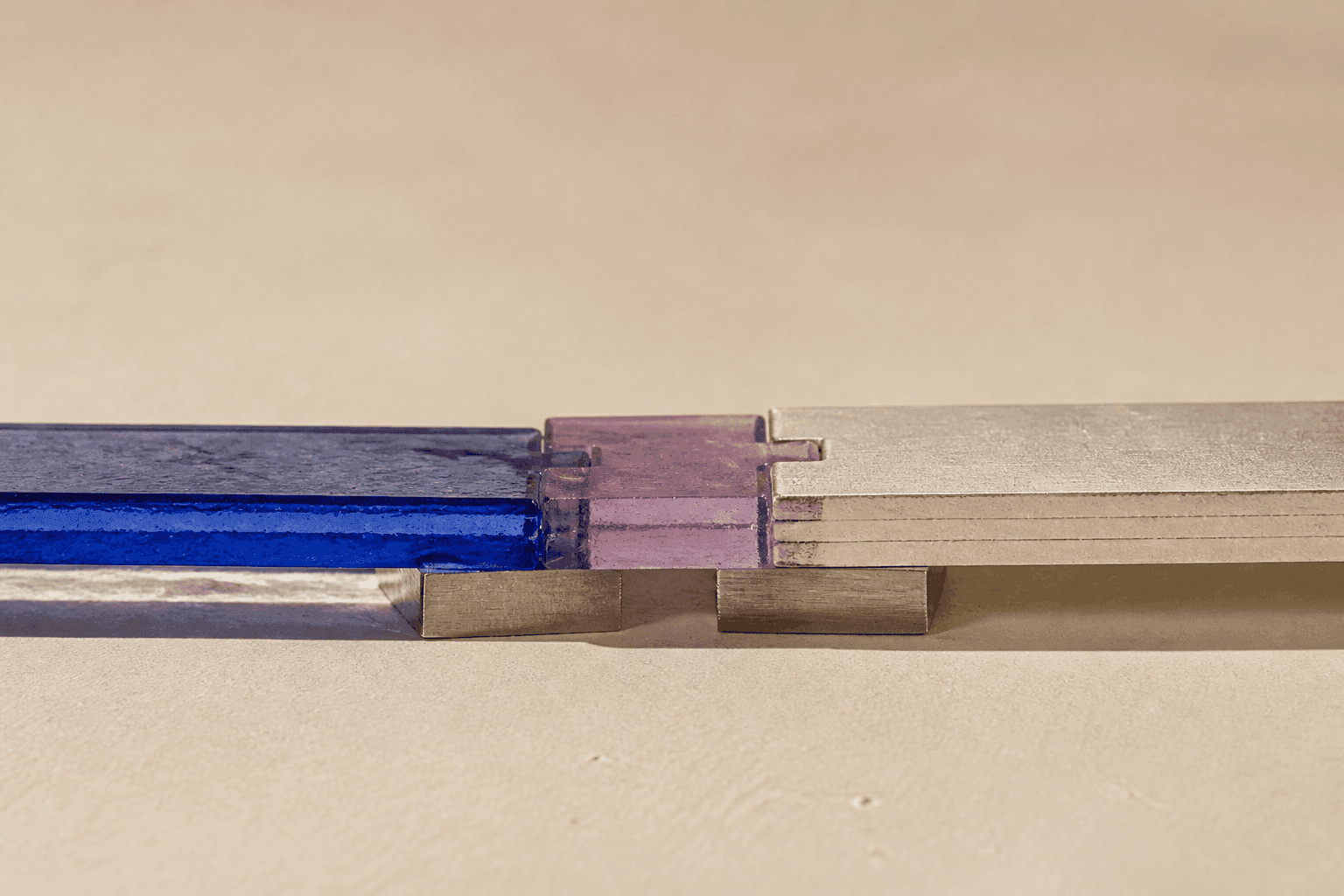 Generated close-up still life showing a cobalt glass strip and a stack of ivory paper joined by a violet resin connector resting on small aluminium supports.